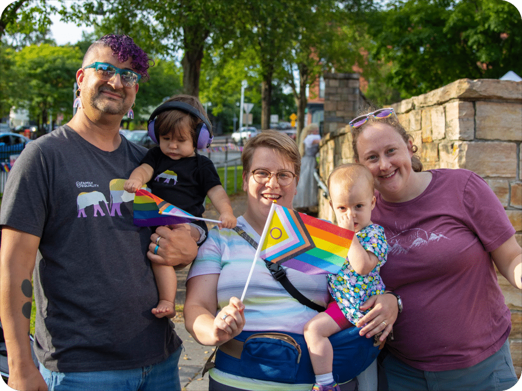 A family waving an intersectional Pride flag at Winooski Pride